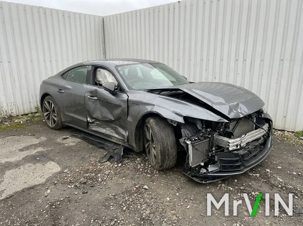 A grey Audi e-tron GT with a destroyed front end and a crushed side